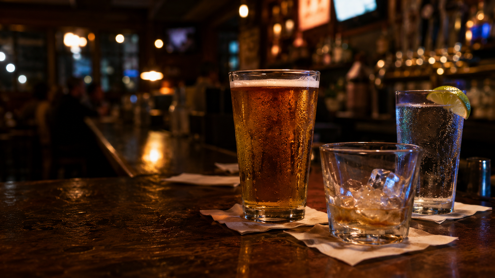 Amber beer, house cocktail, and sparkling water arranged on a neighborhood tavern bar