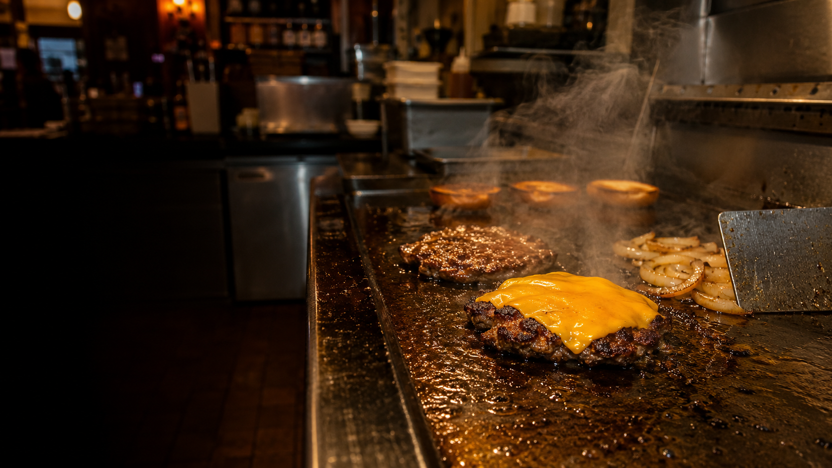 Smash burger patties cooking on a tavern flat-top grill