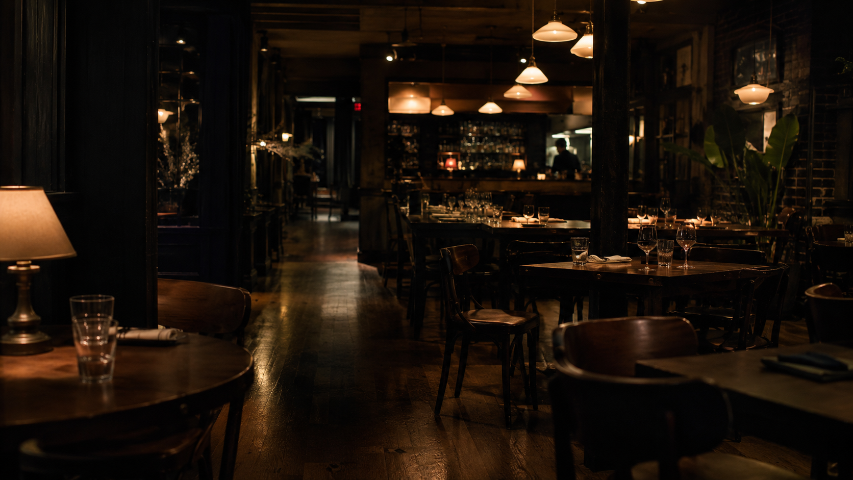 Empty late-night hospitality interior after closing time, lit by warm practical lights.