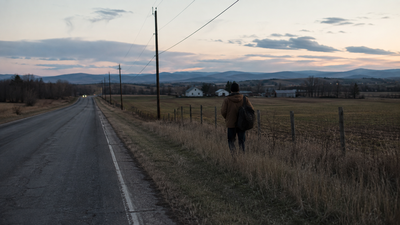 Quiet documentary frame of a solitary traveler near a rural road at dusk in The Long Way Home.